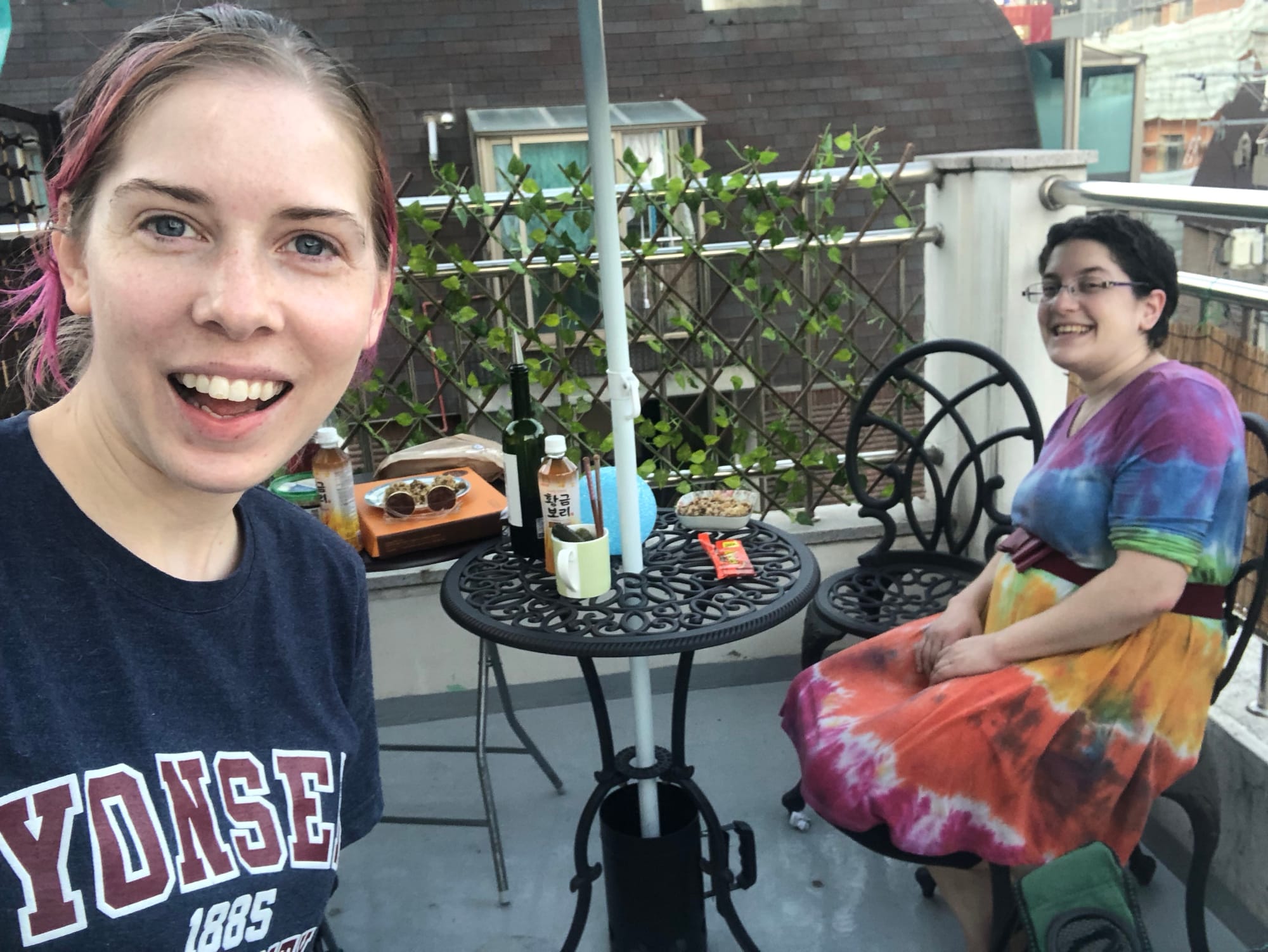 A selfie of Anna Jo, who has pink and brown hair and Tamar, who is wearing a rainbow dress.